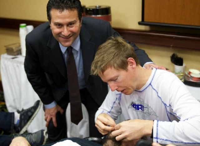 A CFR instructor supervising a doctor practicing Cranial Facial Release at a certification seminar