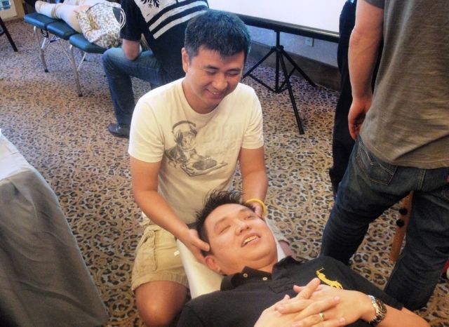 A doctor practicing the Cranial Facial Release technique on a patient at a hands-on seminar