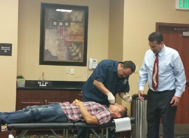 Two CFR doctors treating a patient on a treatment table during a Cranial Facial Release seminar