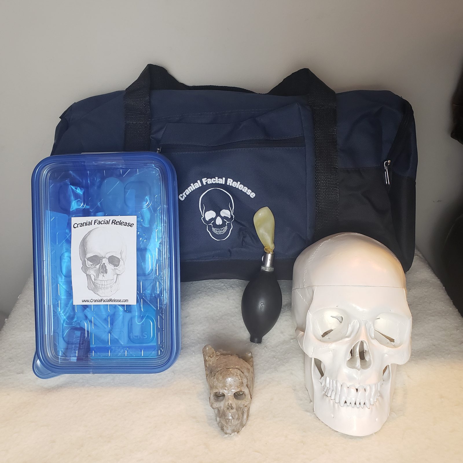 The Cranial Facial Release treatment kit: branded carry bag, nasal balloon inflation device, balloons, and model skull
